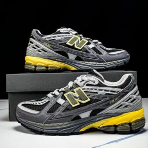 Tenis New Balance gris con detalles amarillos