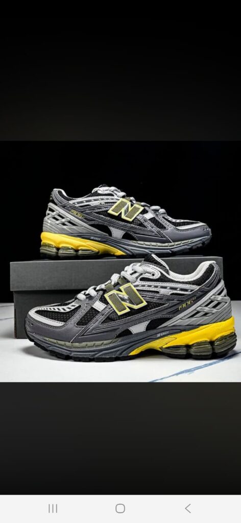 Tenis New Balance gris con detalles amarillos